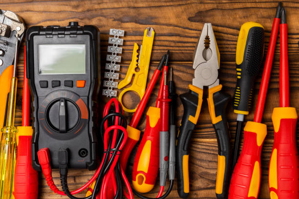 Electrician tools on background. Multimeter,construction tape,electrical tape, screwdrivers,pliers,an automatic insulation stripper, socket and LED lamp. Flatley. electrician concept.