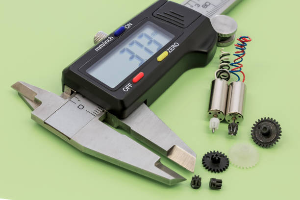 Closeup on a miniature electric motors, nylon gears and vernier calliper  placed on a green background